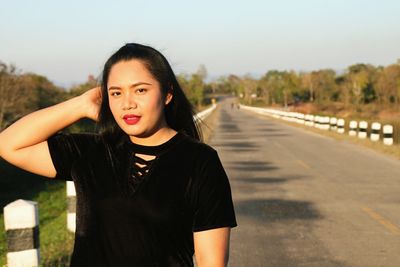 Portrait of beautiful woman standing on roadside