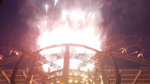 Low angle view of illuminated ferris wheel against sky at night