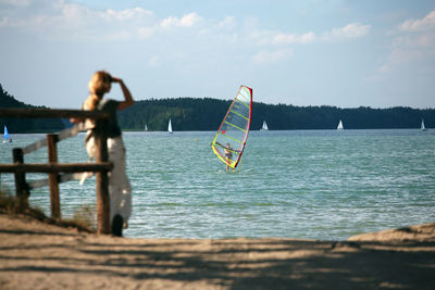 Rear view of woman in sea against sky