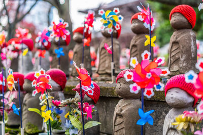 Close-up of statues by pinwheel toy in temple