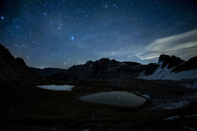 Scenic view of lake against sky at night