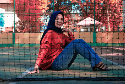Portrait of smiling young woman sitting outdoors