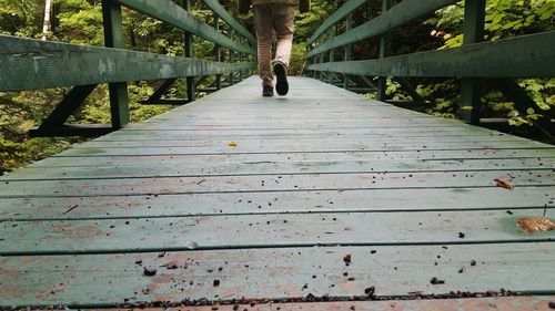 Low section of woman walking on footbridge