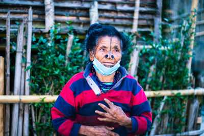 Apatani tribal women facial expression with her traditional nose lobes and blurred background