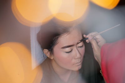 Close-up of young woman holding sparkler at night