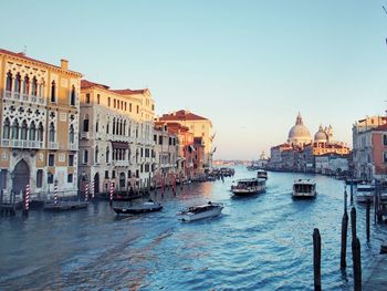 Boats sailing on grand canal amidst buildings against sky