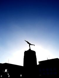 Low angle view of silhouette crane against sky during sunset