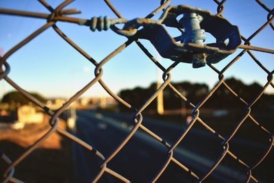 Close-up of chainlink fence against sky