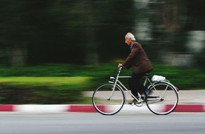 Man riding bicycle on road at night