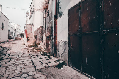 Footpath amidst buildings in city