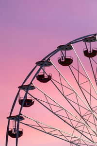 Low angle view of ferris wheel against sky during sunset