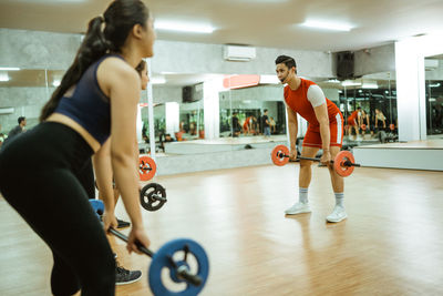 Side view of woman exercising in gym