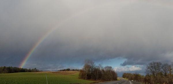 Scenic view of rainbow over land against sky