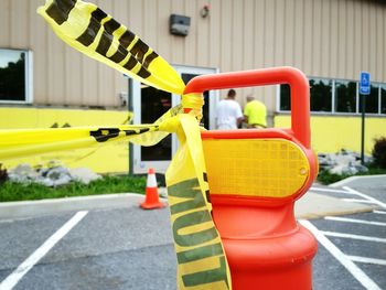 View of yellow safety tape and orange cones on road