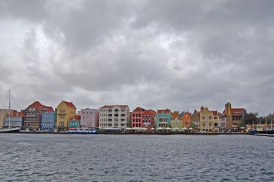 Sea by city against sky