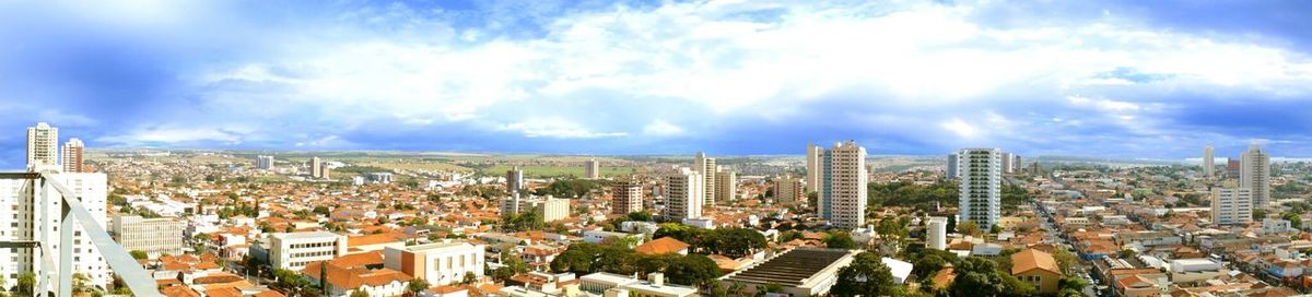 View of cityscape against cloudy sky