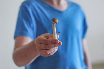 Midsection of man holding edible mushroom