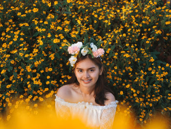 Portrait of a smiling young woman with yellow flower