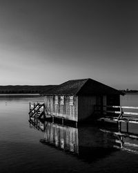 Pier over lake against clear sky