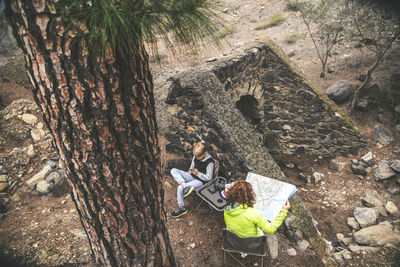 High angle view of woman by son with map at forest