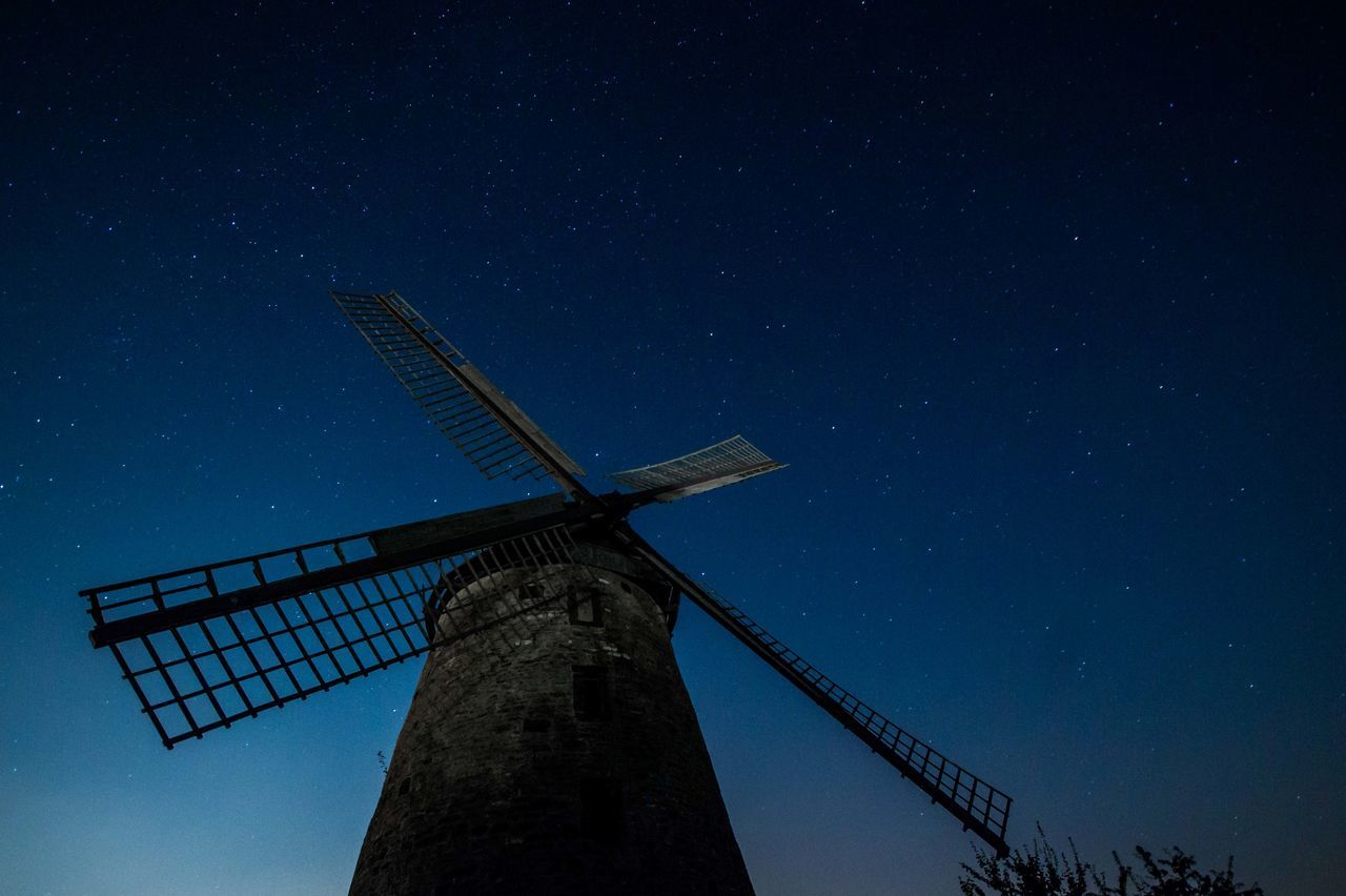 low angle view, alternative energy, wind power, wind turbine, fuel and power generation, windmill, renewable energy, environmental conservation, sky, technology, traditional windmill, built structure, silhouette, night, industry, crane - construction machinery, outdoors, smoke stack, no people, clear sky