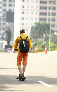 Rear view of man with umbrella on street