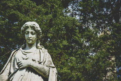 Low angle view of statue against trees