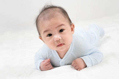 Portrait of cute baby lying on bed