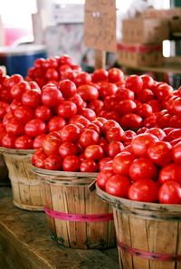 Fresh red organic tomatoes in wooden basket for sale