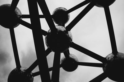 Low angle view of electric lamp hanging against sky