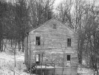 View of built structure with bare trees in foreground