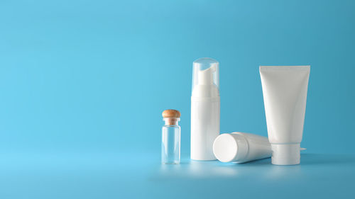 Close-up of white candle on table against blue background