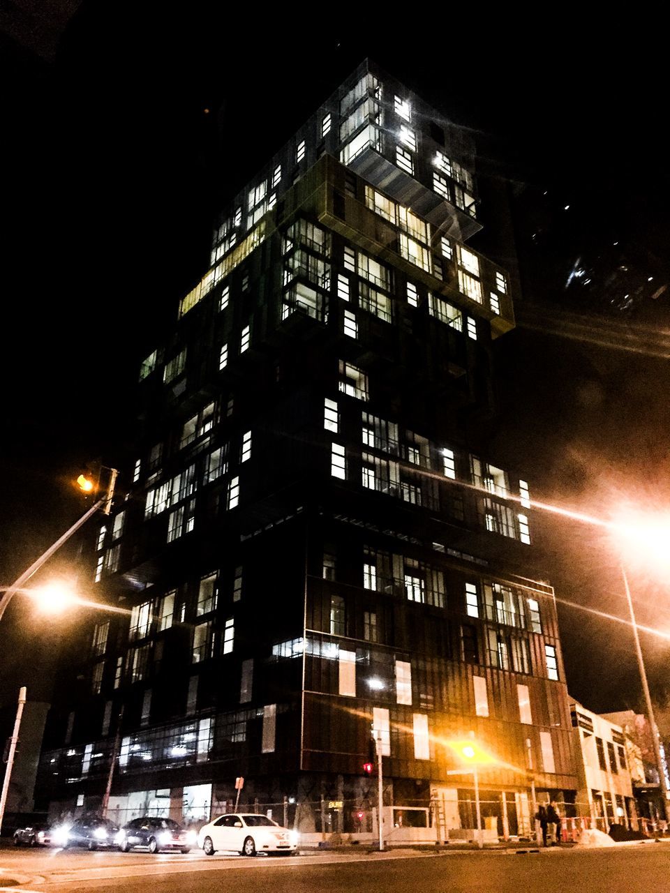 building exterior, architecture, built structure, illuminated, night, city, building, low angle view, street, street light, sky, residential building, city life, office building, modern, skyscraper, outdoors, tower, tall - high, residential structure