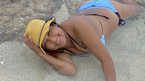 High angle portrait of smiling woman lying on wet floor