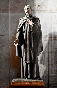 Portrait of young man standing against wall