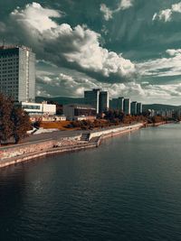 Buildings by sea against sky in city