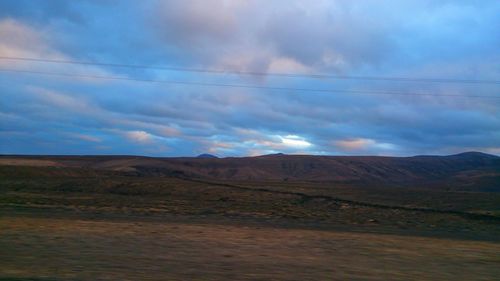 Scenic view of mountains against cloudy sky