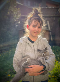 Sunny portrait of young woman with cat