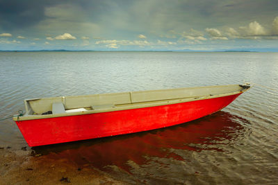 Boat moored on sea against sky