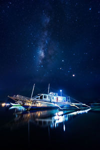 Illuminated sea against sky at night