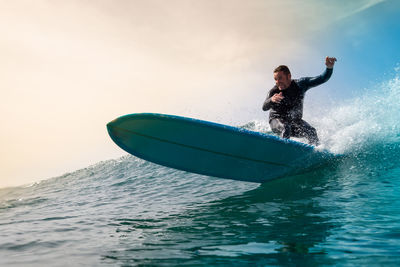 Man surfing on sea against sky