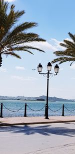 Street light by sea against sky