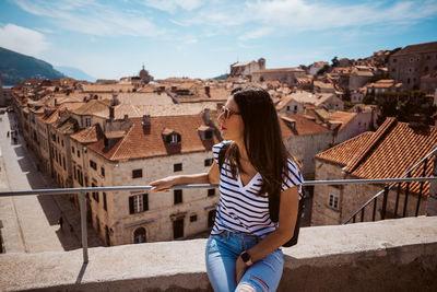 Rear view of woman standing by railing