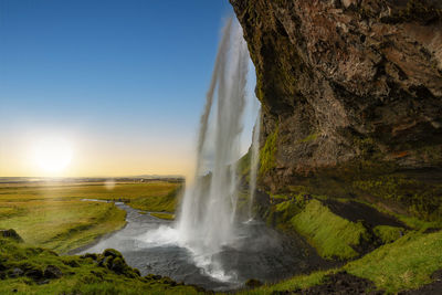 Scenic view of waterfall against sky