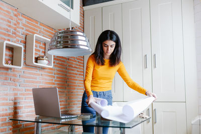 Young woman using phone while standing on table