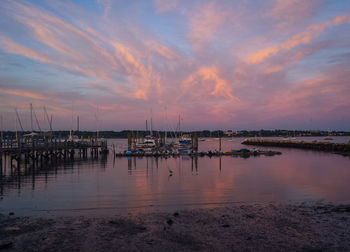 Boats in sea at sunset