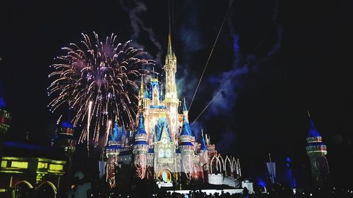 Low angle view of firework display at night