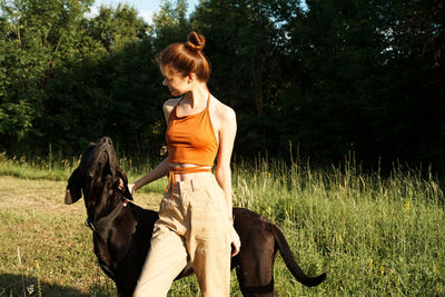 Woman with dog riding horse on grass