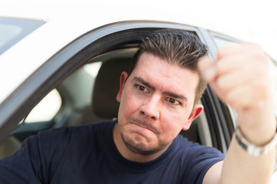 Close-up portrait of mid adult man in car