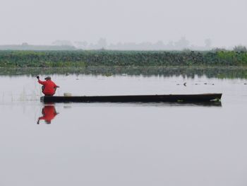 Person in lake against sky